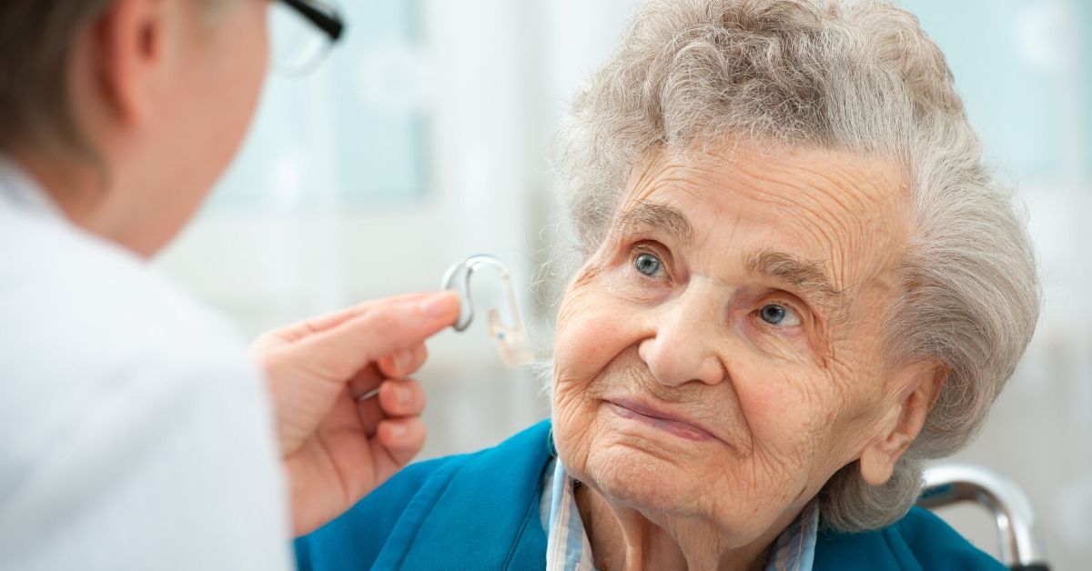 Elderly woman gets fitted for hearing aids through Amplifon, who uses CXone.
