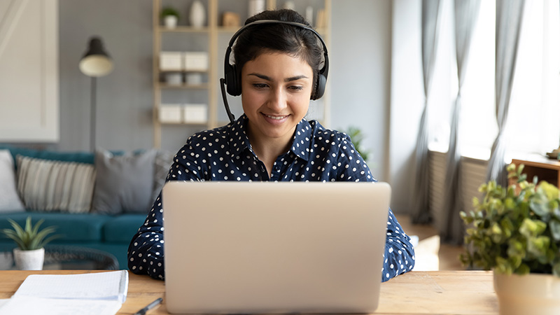 Smiling woman with headset and laptop